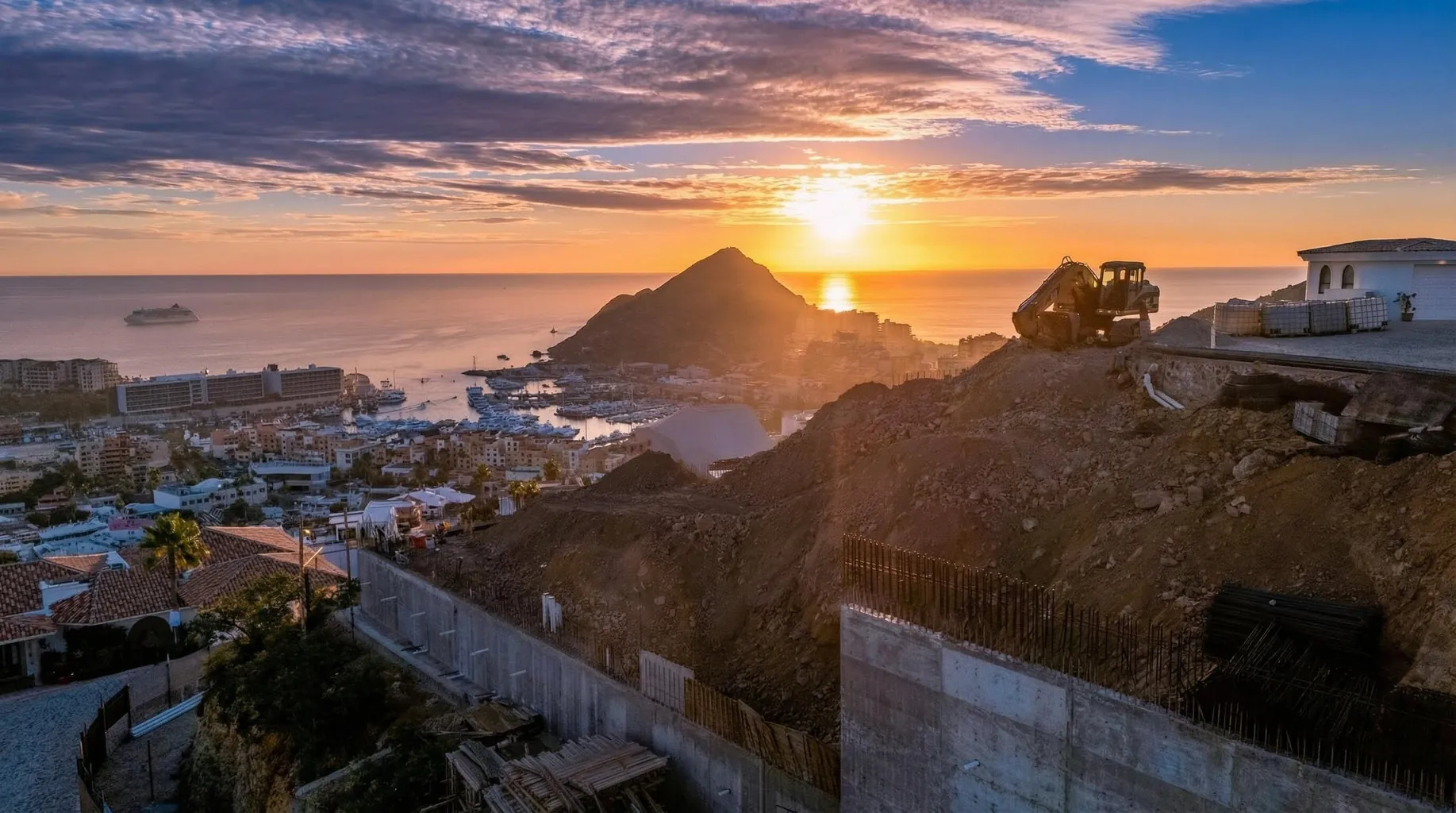 Villa del León under construction in Pedregal, Cabo San Lucas — sunset over the marina and Land’s End